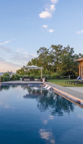 Outdoor pool with lounge chairs and a pergola on a landscaped estate